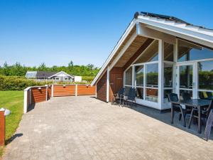 a house with a patio with a table and chairs at 8 person holiday home in Hemmet in Hemmet