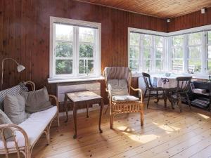 a living room with a table and chairs and windows at 6 person holiday home in Gilleleje in Gilleleje