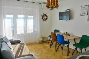 un salon avec une table et des chaises dans l'établissement Apartmani Krijesnica, à Senj