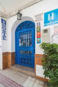 una puerta azul en el lateral de un edificio en Hostal San Ramón en Marbella
