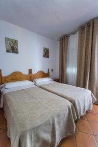 dwa łóżka siedzące obok siebie w pokoju w obiekcie Hostal San Ramón w Marbelli