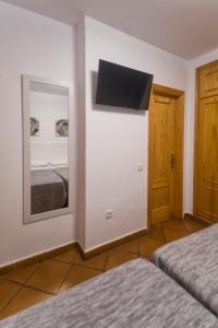 a room with two beds and a mirror and a door at Hostal San Ramón in Marbella +48 photos