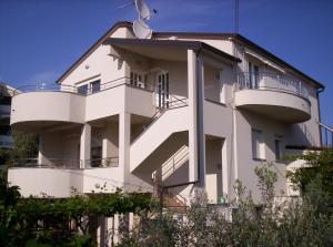 a white building with balconies on the side of it at Apartment for Two 200m from the Beach in Pula