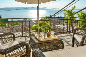 einen Tisch und Stühle auf einem Balkon mit Meerblick in der Unterkunft Apartmani Krijesnica in Senj