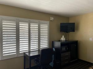 a room with a desk and a tv and a window at Pinewood Inn in South Lake Tahoe