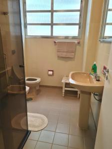 a bathroom with a toilet and a sink and a shower at Apartamento Das Conchas Praia das Pitangueiras in Guarujá