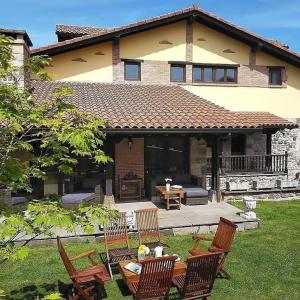 une maison avec une table et des chaises dans la cour dans l'établissement La Riguera de Ginio, à Ucieda de Arriba
