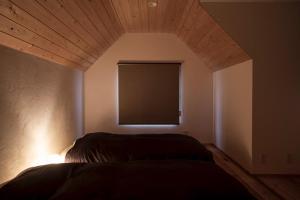 a bedroom with a bed with a wooden ceiling and a window at Nikko, Matsubara no Yado - Vacation STAY 31914v in Nikko