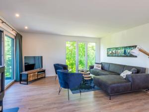 ein Wohnzimmer mit einem Sofa und einem TV in der Unterkunft Lovely holiday home in a quiet location, equipped with every comfort in Kamperland
