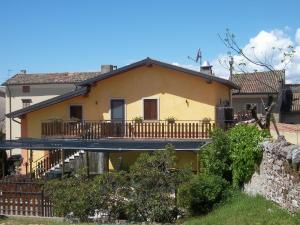 Una gran casa amarilla con balcón frente a ella en Le Bottesele, en San Zeno di Montagna