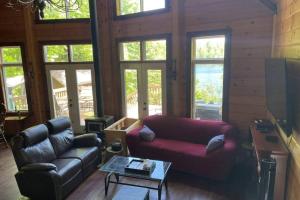 a living room with a couch and a coffee table at Joy's Chalet - Hottub, Lake, & Cottage in Val-des-Bois