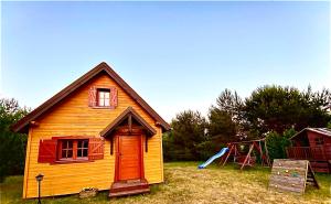 a small house with a playground and a swing at Domek w sercu Kaszub in Sominy
