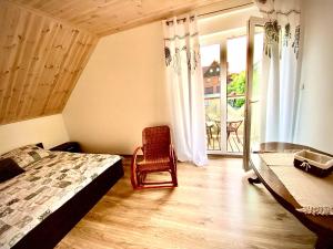 a bedroom with a bed and a chair and a window at Dom Kaszubka Oaza in Sominy