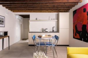 Una cocina y un comedor con mesa y sillas. en Palazzo Venere Apartments, en Venecia