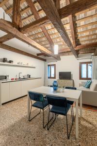 een keuken en een woonkamer met een tafel en stoelen bij Palazzo Venere Apartments in Venetië