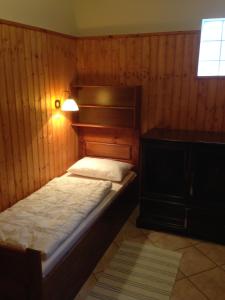 Dormitorio pequeño con cama y lámpara en Juhász Fogadó, en Fonyód