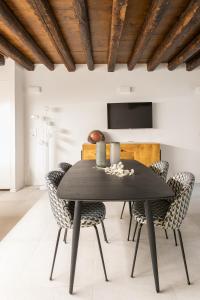 a dining room with a black table and chairs at Palazzo Venere Apartments in Venice