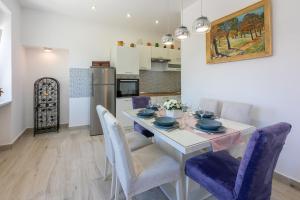 a kitchen and dining room with a table and chairs at House TINAC in Crikvenica