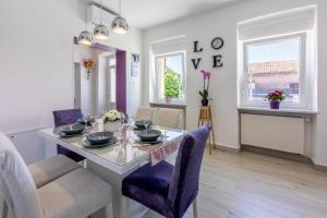 a dining room with a table and purple chairs at House Tinac in Crikvenica