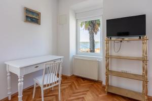 a room with a desk and a tv and a window at House TINAC in Crikvenica