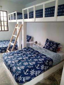 1 dormitorio con 2 literas y manta azul y blanca en Portón Náutica, en San Bernardo del Viento