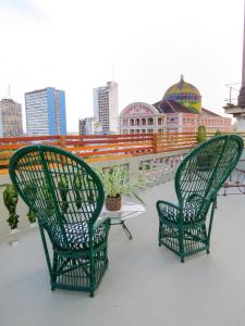 two green chairs and a table on a roof at Hotel Casa Dos Frades in Manaus