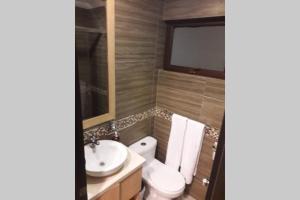 a bathroom with a toilet and a sink at Hermoso apartamento en condominio La Victoria in Cuenca