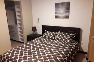 a bedroom with a bed with a black and white comforter at Hermoso apartamento en condominio La Victoria in Cuenca