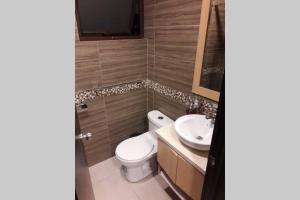 a bathroom with a toilet and a sink at Moderno departamento 3B en Condominio La Victoria in Cuenca