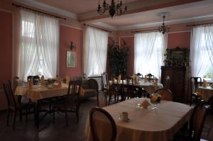 a dining room with tables and chairs and windows at Restauracja - Hotel Pałacowa in Rogowo