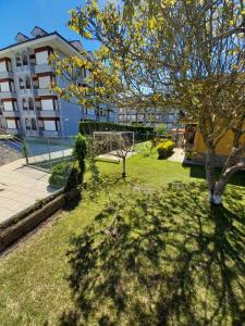 a park with a tree and a building at Villa La Rufina Noja in Noja