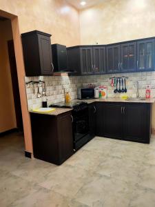 a kitchen with black cabinets and black appliances at Heavenly ApHEARTment With a Swimming Pool in Dodoma