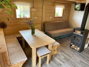 ein Wohnzimmer mit einem Tisch und einem Herd in der Unterkunft Miha`s cottage in Bohinj