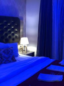 a blue bedroom with two beds with blue curtains at Virginia Hotel in Amman