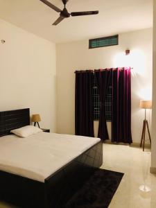 Schlafzimmer mit einem Bett und einem Deckenventilator in der Unterkunft Tattva 2 in Varanasi