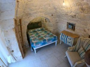a room with a bed in a stone wall at Trullo Nadia Ostuni in Ostuni