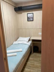 a small room with a bed and a desk at CapsulePlus in Tbilisi City