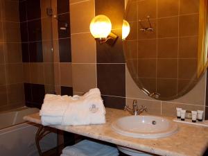 a bathroom with a sink and a tub and a mirror at Delphi Art Hotel by Prima Hotels in Athens