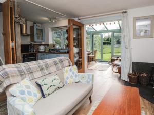 uma sala de estar com um sofá e uma mesa em Wood Glen Cottage em Dallington