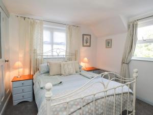 a bedroom with a white bed and a window at Wood Glen Cottage in Dallington