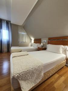 a bedroom with two beds and a window at Hotel La Cuesta in Tapia de Casariego