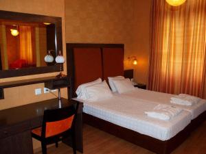 a bedroom with a bed and a desk and a mirror at Delphi Art Hotel by Prima Hotels in Athens