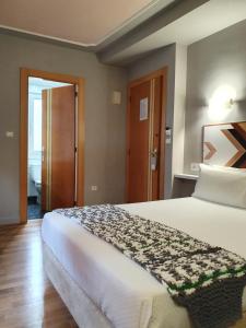 1 dormitorio con 1 cama grande y baño en Hotel La Cuesta, en Tapia de Casariego