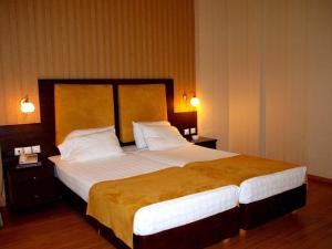 a bedroom with a large bed with white sheets and pillows at Delphi Art Hotel by Prima Hotels in Athens