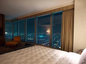 a bedroom with a view of a city at night at Osaka Marriott Miyako Hotel in Osaka