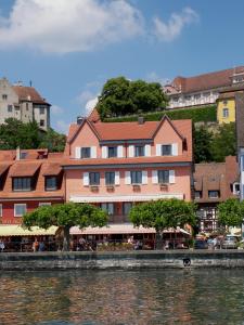 a building on the side of a river next to a building at Hotel Strand-Cafe Meersburg in Meersburg
