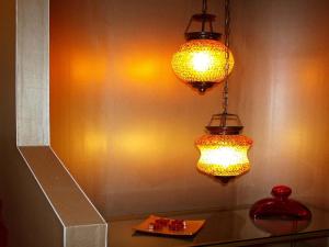 two lights hanging from a wall with a table at Delphi Art Hotel by Prima Hotels in Athens