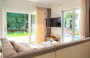 ein Wohnzimmer mit Couch und großem Fenster in der Unterkunft Villa Hedera in Dramalj
