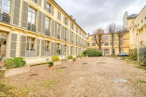un patio vacío frente a un gran edificio en Le Richelieu en Versailles