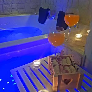 two glasses of wine sitting on a table next to a bath tub at B&B Napoli Centrale Room&Jacuzzi in Naples